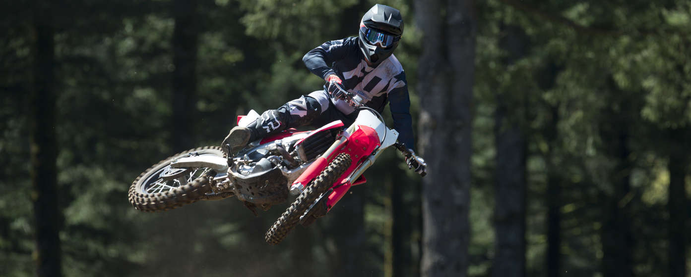 Pohľad spredu na motocykel Honda CRF450R počas skoku s jazdcom.