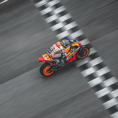 Jazdec Honda v pretekoch MotoGP prech&aacute;dza cieľovou čiarou.