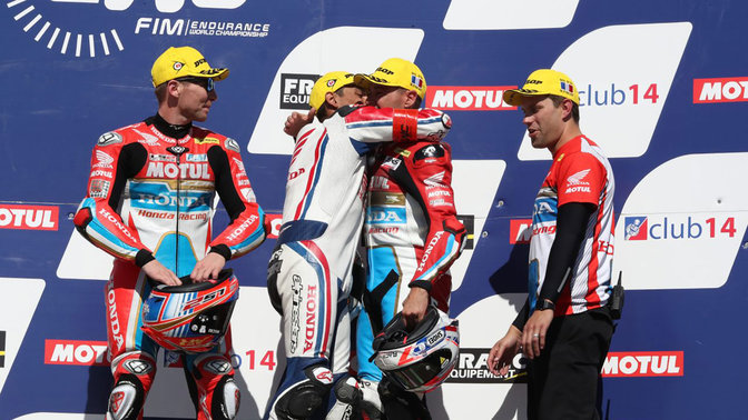 Jazdci na motocykli Honda EWC oslavujúci víťazstvo.