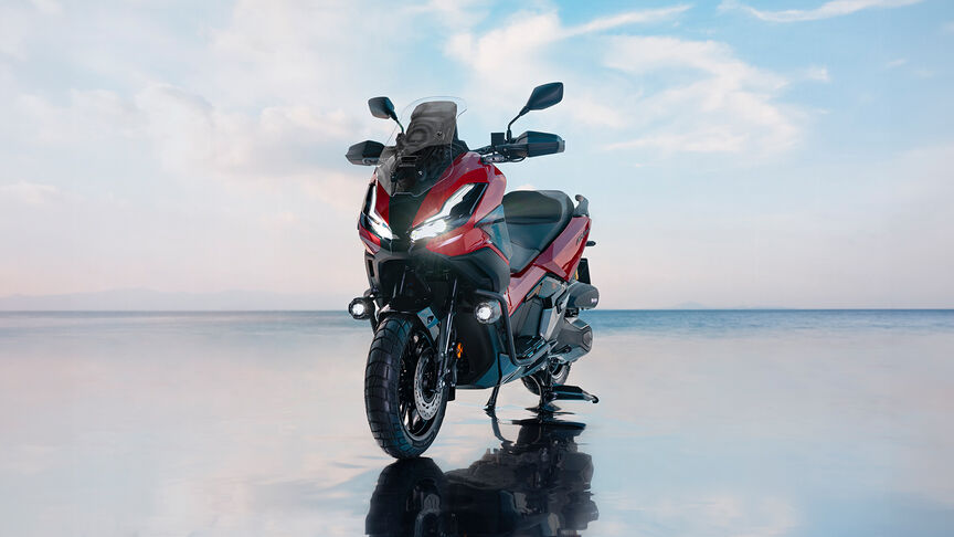 Trojštvrťový záber spredu na skúter Honda ADV350 na pobreží.
