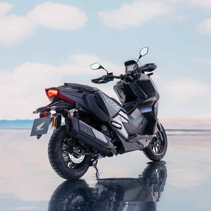 Trojštvrťový pohľad zozadu na model Honda ADV350 na pobreží. 