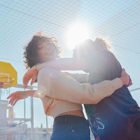 Dvaja figuranti sa objímajú v slnečnom svetle na modeli EM1 e: fotografovanie