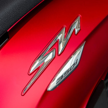 Honda SH350i, priblížený pohľad na logo SH, červený motocykel