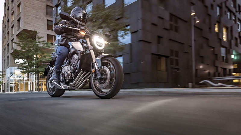 CB650R Neo Sports Café, trojštvrťový predný pohľad z pravej strany na stroj s jazdcom v meste