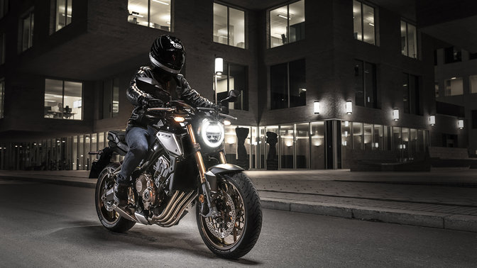 CB650R Neo Sports Café, trojštvrťový predný pohľad z pravej strany na stroj s jazdcom v nočnom meste