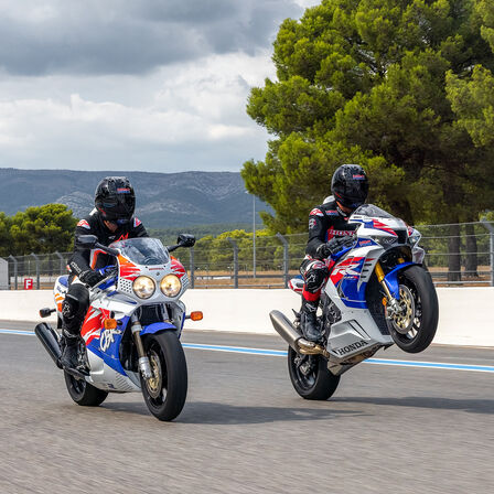 Pohľad zboku na tri modely Honda CBR1000RR-R Fireblade a Fireblade SP zaparkované na pretekárskej trati
