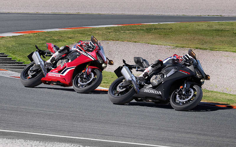 Dva motocykle CBR1000RR Fireblade trojštvrťový predný záber z pravej strany v ostrej zákrute