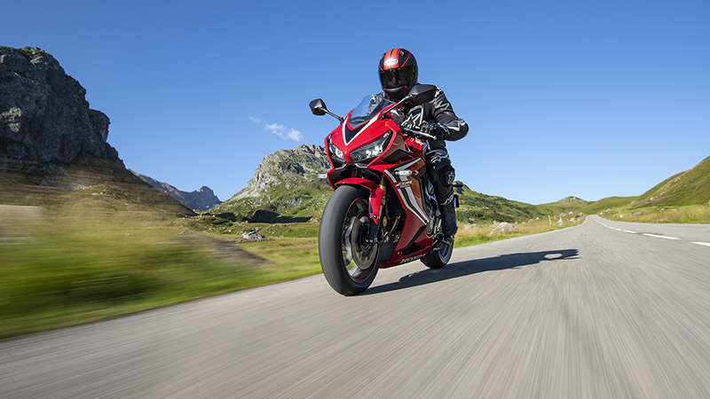 CBR650R, trojštvrťový pohľad spredu z ľavej strany na jazdca jazdiaceho po horskej ceste