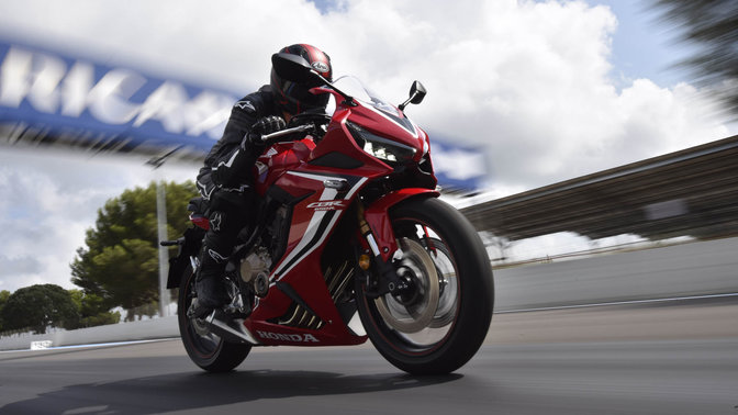 CBR650R, trojštvrťový pohľad spredu z pravej strany na stroj s jazdcom rýchlo jazdiaci po pretekárskej trati