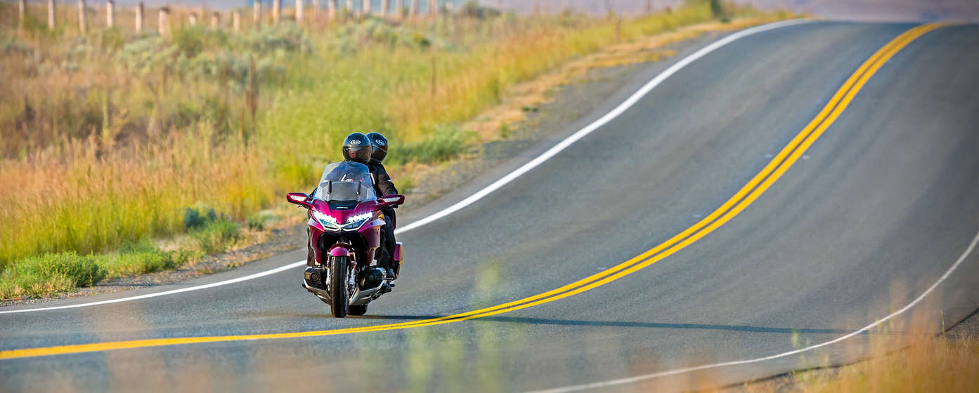 Jazdec so spolujazdcom na motocykli Honda Goldwing.