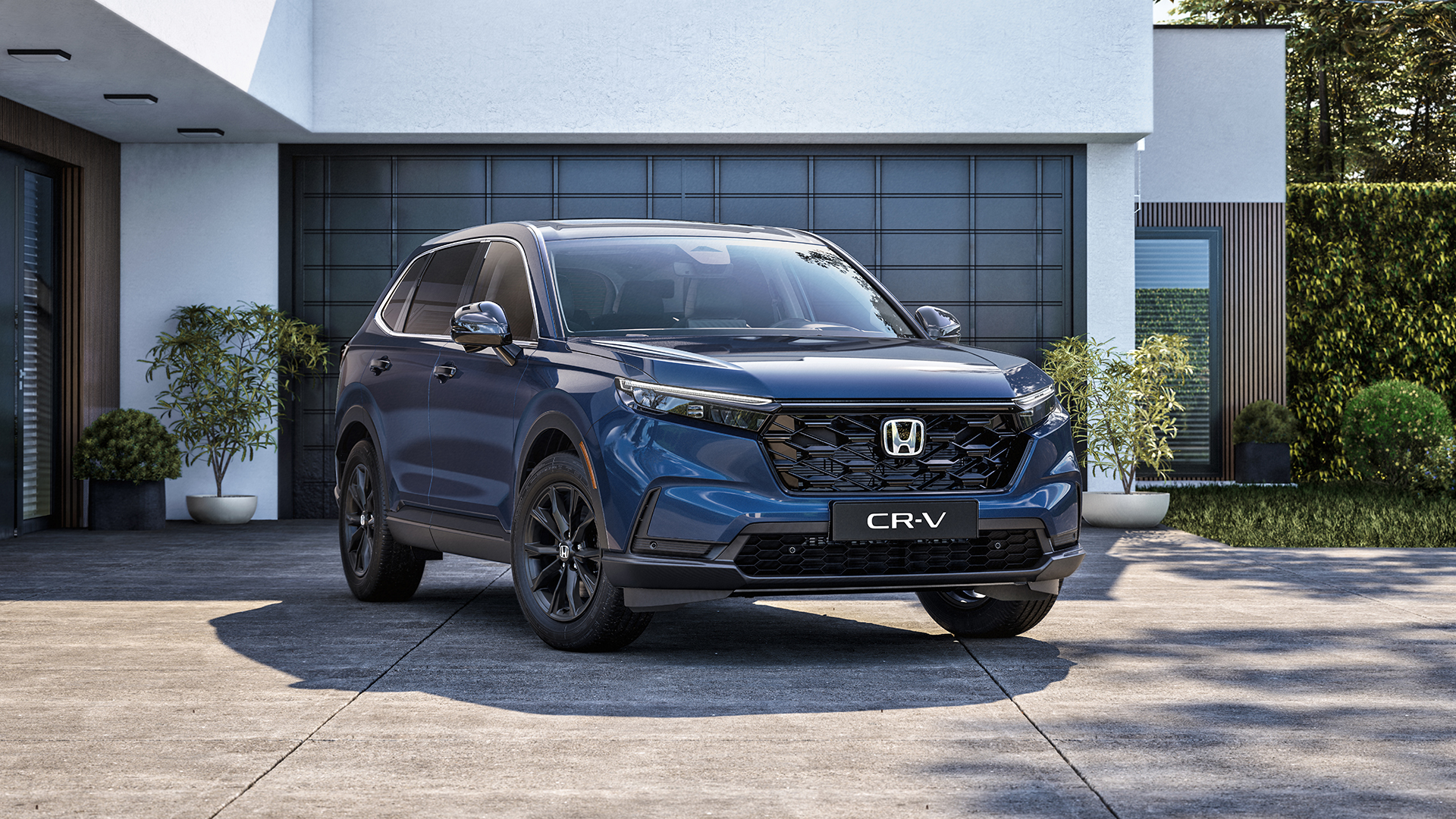 Strieborné SUV Honda CR-V jazdiace po kľukatej horskej ceste s skalnatým terénom a hrami v pozadí. Vozidlo je v pohybe, čo vytvára pocit rýchlosti a dobrodružstva v drsnej krajine.